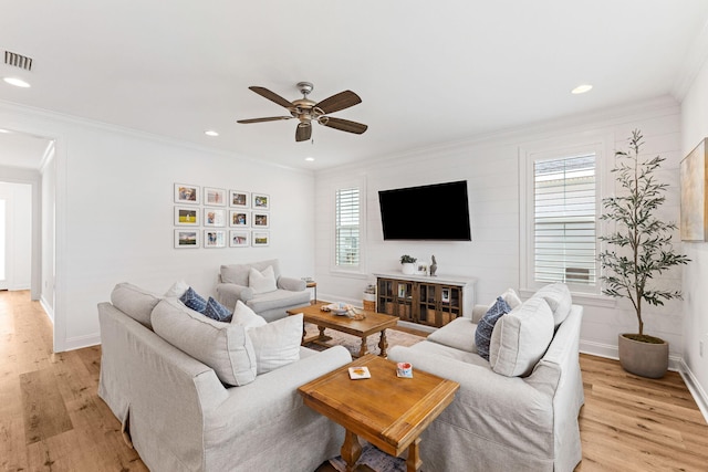 living room with crown molding, light hardwood / wood-style flooring, and ceiling fan