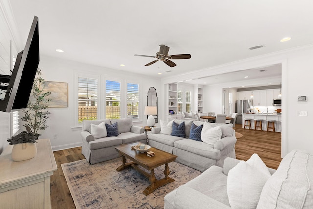 living room featuring light wood-type flooring, crown molding, and ceiling fan