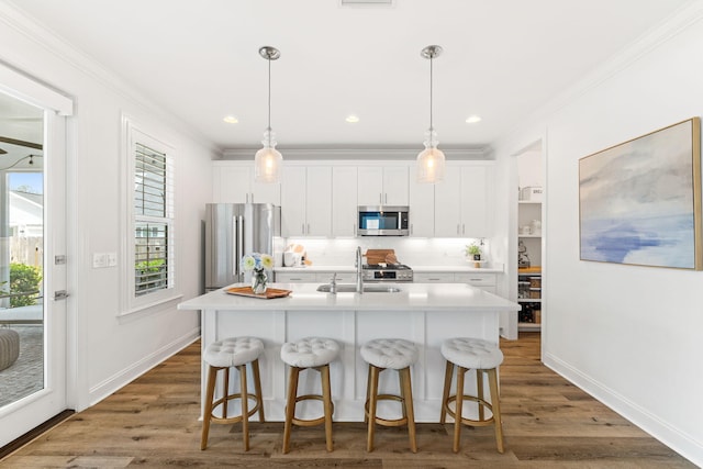 kitchen with an island with sink, stainless steel appliances, and white cabinetry