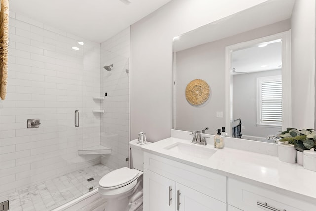 bathroom with vanity, toilet, and a shower with door