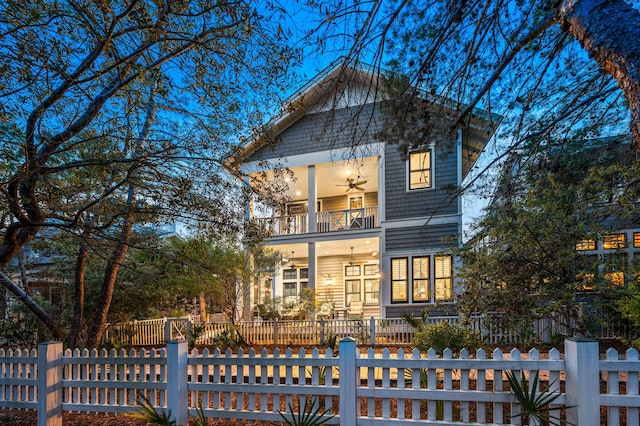 view of front of house with a balcony, a fenced front yard, and ceiling fan