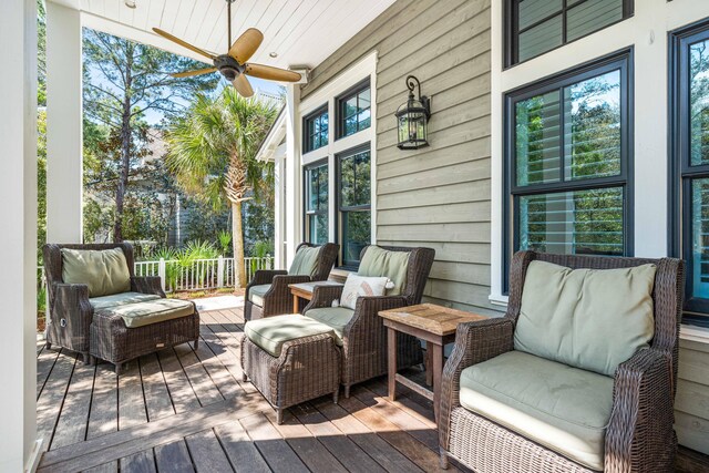 wooden terrace with ceiling fan and an outdoor hangout area