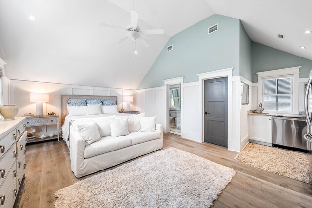 bedroom featuring high vaulted ceiling, light hardwood / wood-style flooring, sink, and ceiling fan