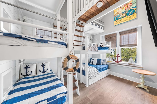 bedroom with wood-type flooring and a high ceiling