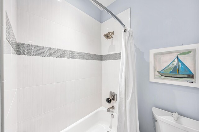 bathroom featuring shower / bath combo with shower curtain and toilet