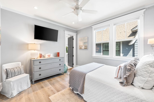 bedroom featuring light hardwood / wood-style flooring, ceiling fan, and ornamental molding