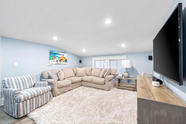 living room with hardwood / wood-style flooring and vaulted ceiling