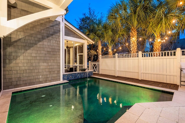 view of pool at twilight