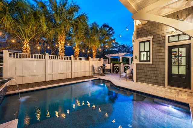 pool at dusk featuring a patio area