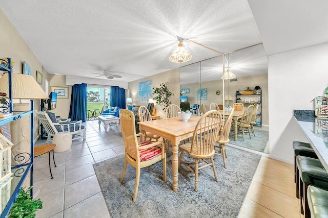 dining room featuring ceiling fan with notable chandelier, a textured ceiling, and light tile patterned flooring