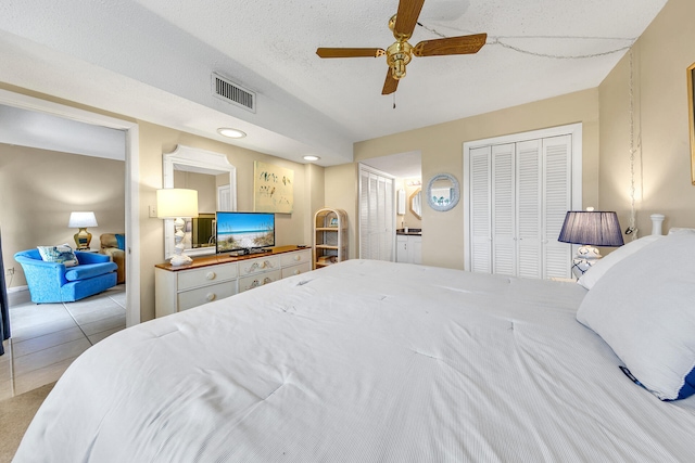 tiled bedroom with a textured ceiling and ceiling fan