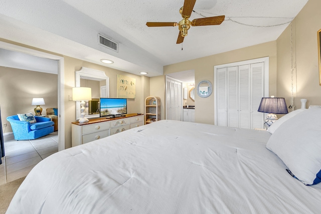 909 Santa Rosa Blvd Unit 211, Fort Walton Beach, FL 32548 - tiled bedroom with ensuite bathroom, a textured ceiling, visible vents, two closets, and ceiling fan