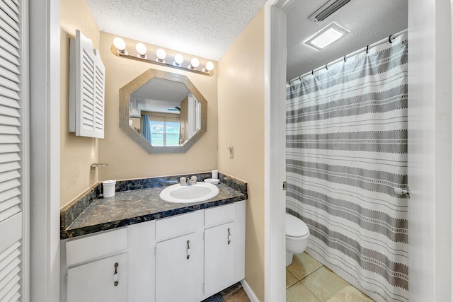 bathroom with vanity, toilet, a textured ceiling, and tile patterned flooring