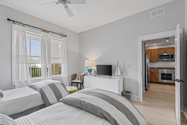 bedroom with visible vents, a ceiling fan, freestanding refrigerator, light wood-style floors, and baseboards