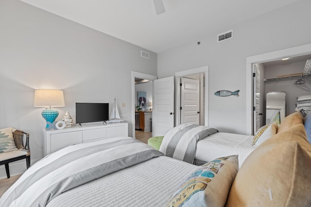 bedroom with light wood finished floors, visible vents, a spacious closet, and a closet