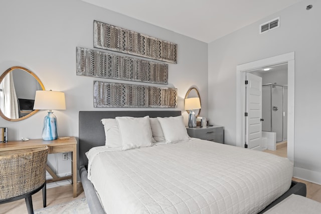 bedroom with visible vents, baseboards, and wood finished floors