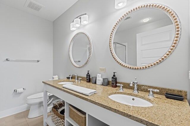 bathroom with vanity, toilet, tile patterned floors, and a shower with shower door