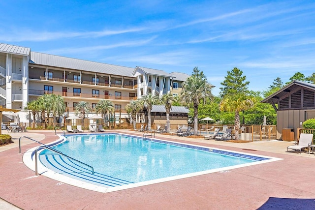 view of swimming pool with a patio and fence