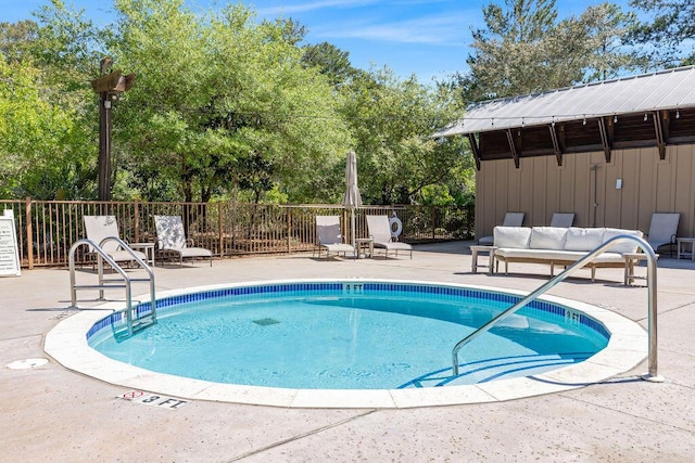 view of swimming pool with a patio and fence