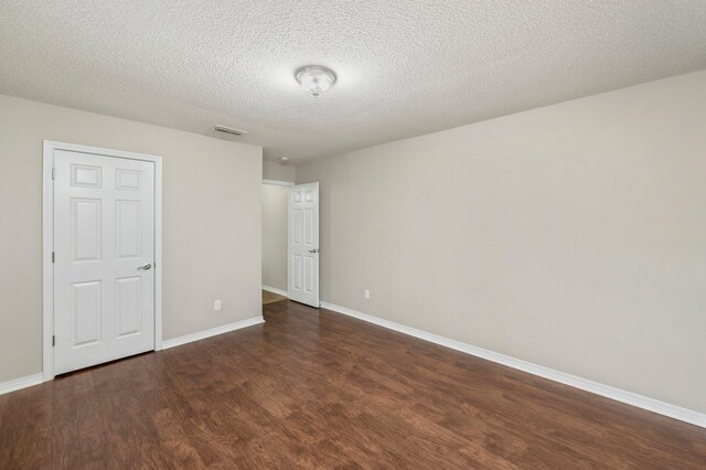 unfurnished bedroom with a textured ceiling and dark wood-type flooring