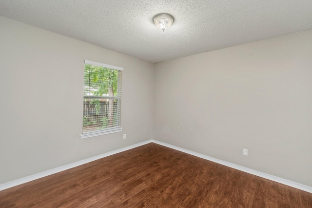 empty room with hardwood / wood-style floors and a textured ceiling