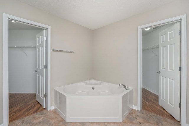 bathroom featuring a textured ceiling, hardwood / wood-style floors, and a washtub