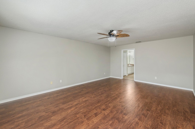 empty room featuring visible vents, a textured ceiling, wood finished floors, baseboards, and ceiling fan