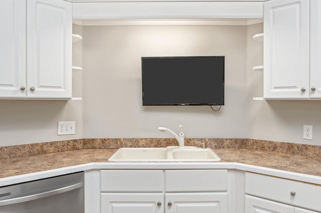 kitchen featuring stainless steel dishwasher, sink, and white cabinets