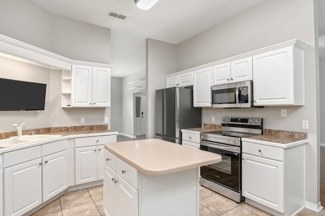 kitchen with visible vents, a sink, white cabinets, stainless steel appliances, and open shelves