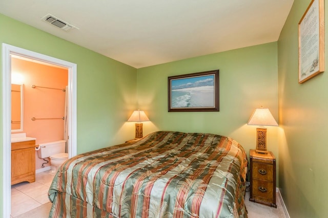 bedroom featuring connected bathroom and light tile patterned flooring