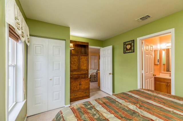 carpeted bedroom featuring connected bathroom and a closet