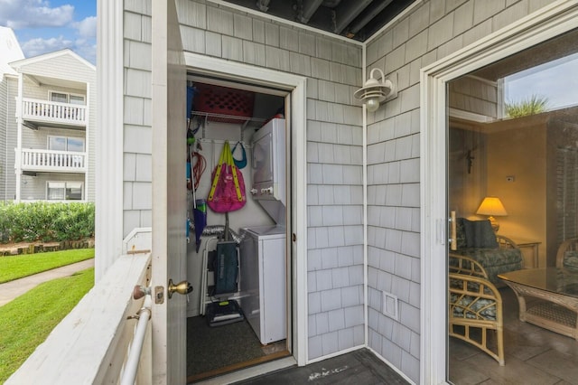 property entrance with stacked washer and clothes dryer