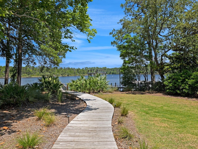 surrounding community with a water view and a yard