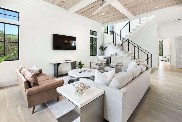 living room featuring beamed ceiling, wooden ceiling, and light hardwood / wood-style floors