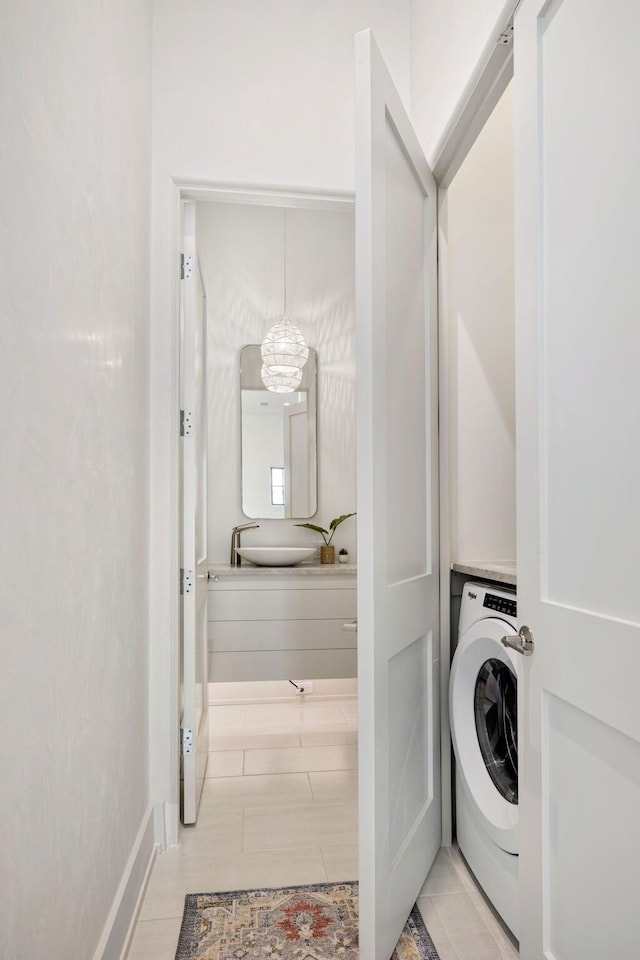 washroom featuring washer / clothes dryer, a chandelier, and sink