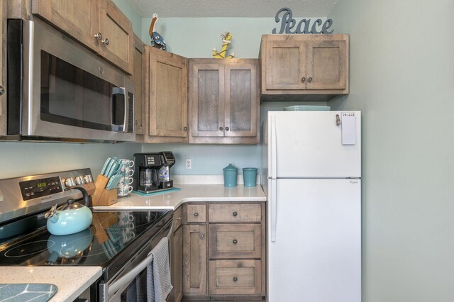 kitchen with a textured ceiling and stainless steel appliances