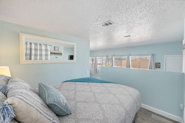 bedroom featuring hardwood / wood-style flooring and a textured ceiling