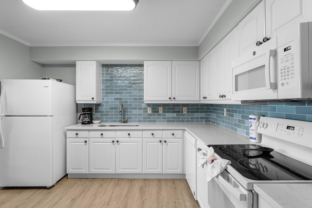 kitchen featuring white appliances, a sink, light countertops, white cabinets, and light wood-type flooring