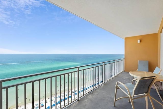 balcony featuring a view of the beach and a water view