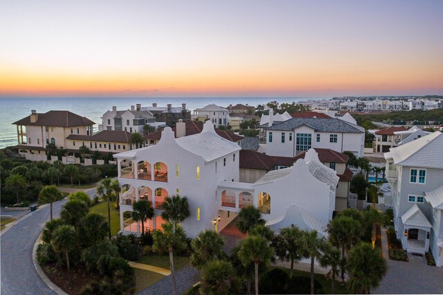 aerial view at dusk featuring a water view