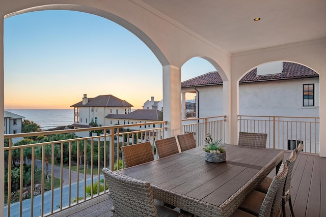 deck featuring outdoor dining area and a water view