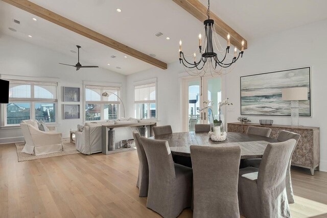 dining space featuring ceiling fan with notable chandelier, high vaulted ceiling, light hardwood / wood-style flooring, and beam ceiling