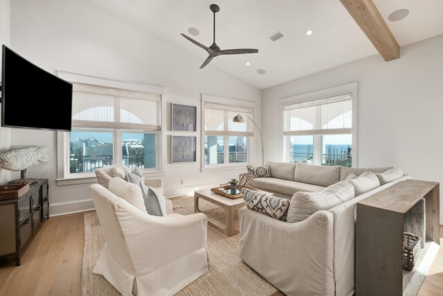 living room featuring light wood-type flooring, ceiling fan, and lofted ceiling with beams