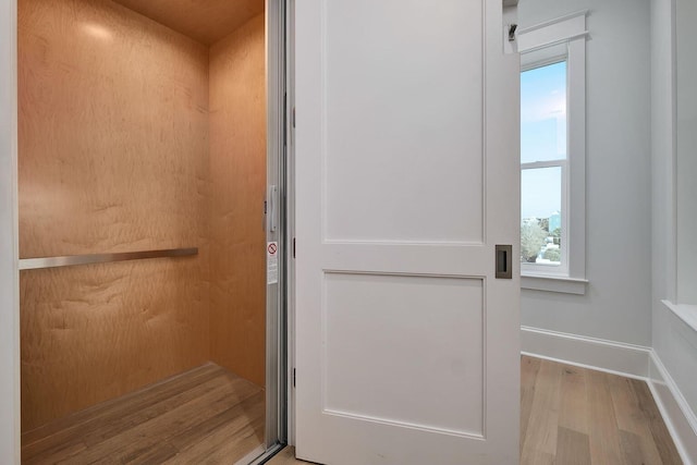 bathroom featuring hardwood / wood-style flooring and elevator