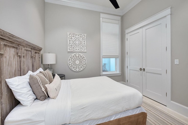 bedroom with ceiling fan, a closet, wood finished floors, and ornamental molding