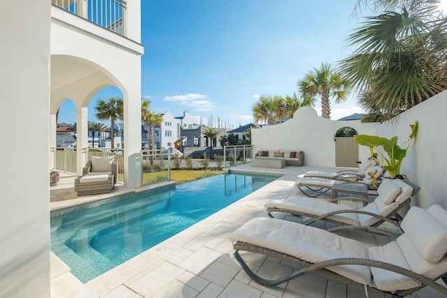 outdoor pool featuring a patio area and fence