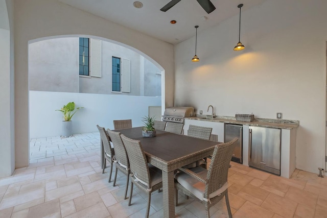 dining room with a high ceiling, ceiling fan, and sink