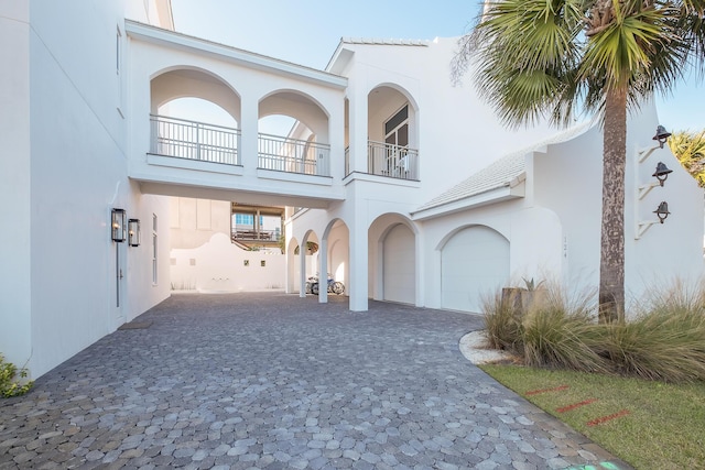 exterior space featuring decorative driveway, a garage, and stucco siding