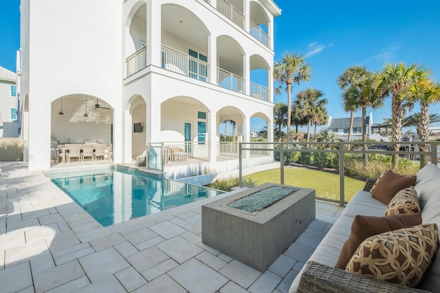 exterior space featuring a patio area, an outdoor living space with a fire pit, outdoor dining area, and fence