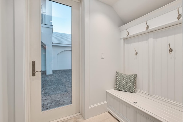 mudroom featuring lofted ceiling and light tile patterned flooring